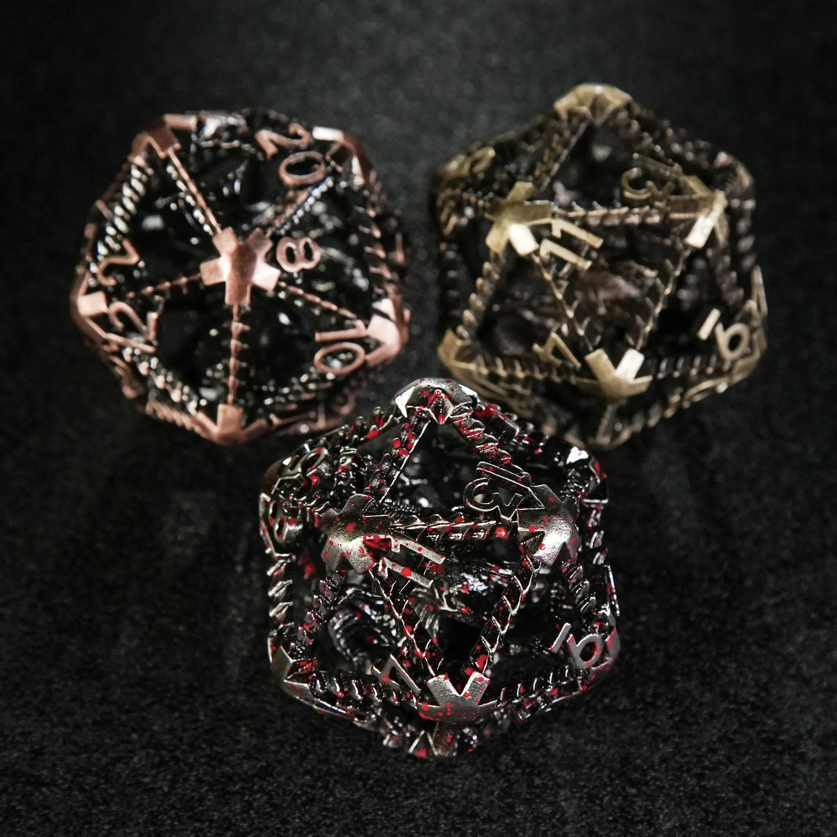 Dragon Metal D20 Dice – Three large 40mm metal hollow dragon D20 dice (blood, copper, and bronze) placed on a black